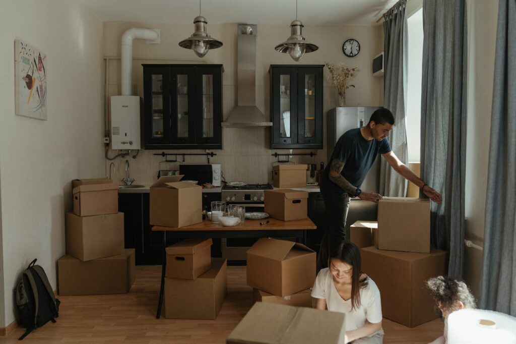 Family in small kitchen, studio, cardboard boxes, moving
