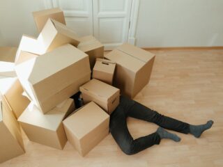 A person under a pile of cardboard boxes