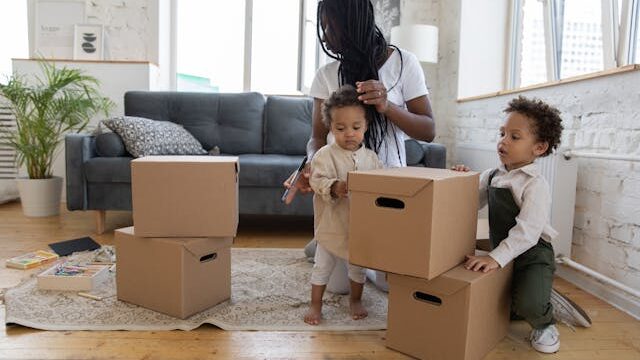 A mother with her two children packing boxes