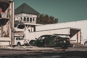 Green race car being unloaded from the trailer