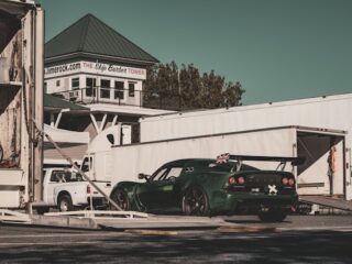 Green race car being unloaded from the trailer