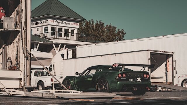 Green race car being unloaded from the trailer