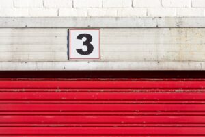 Red doors to a storage unit with the number three