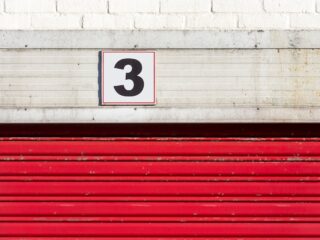 Red doors to a storage unit with the number three
