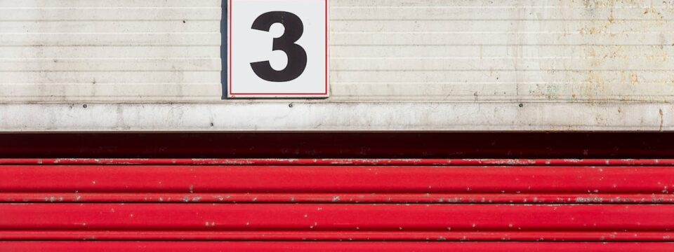 Red doors to a storage unit with the number three
