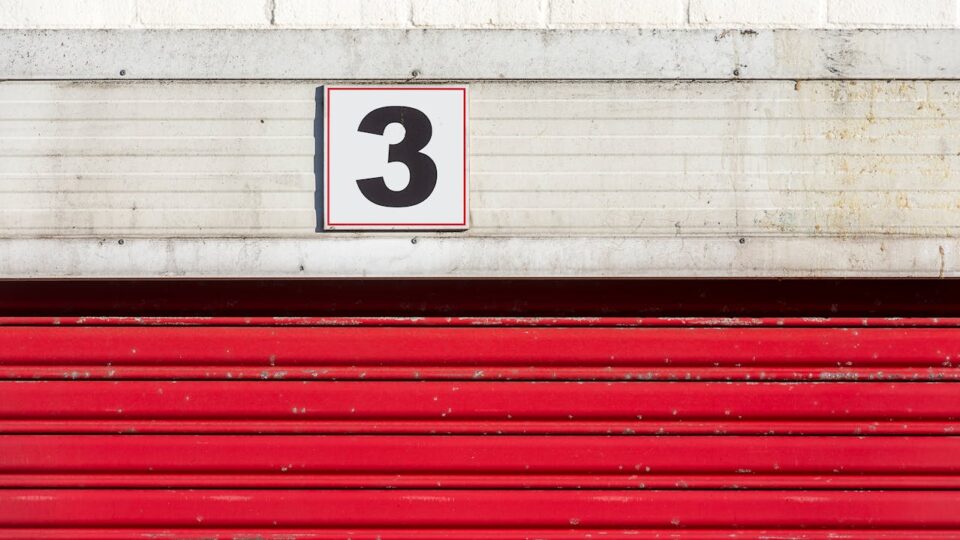 Red doors to a storage unit with the number three