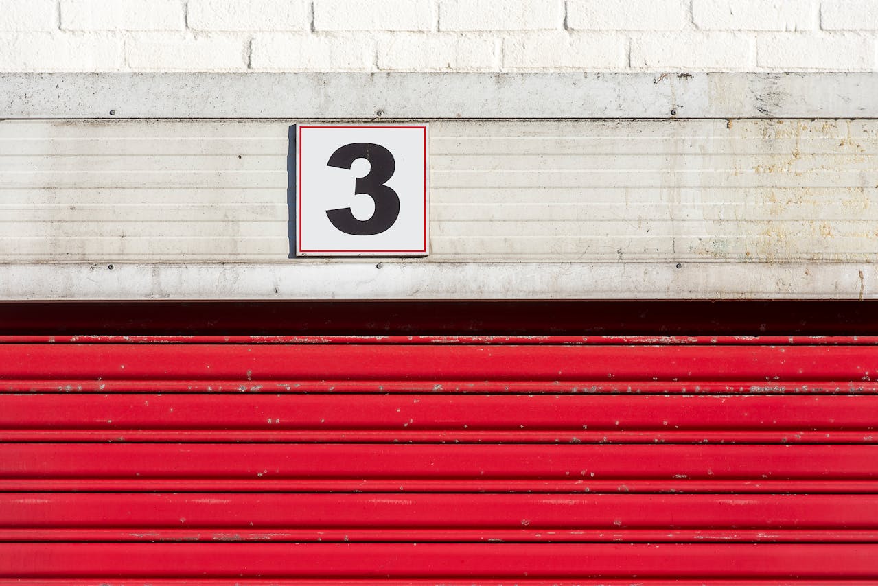 Red doors to a storage unit with the number three
