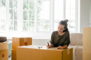 woman labeling boxes and looking for smart storage solutions for seasonal home transitions
