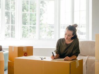 woman labeling boxes and looking for smart storage solutions for seasonal home transitions