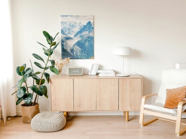 A cozy modern living room with a gray lounge chair and soft pillows showing how to repurpose old furniture for modern spaces.