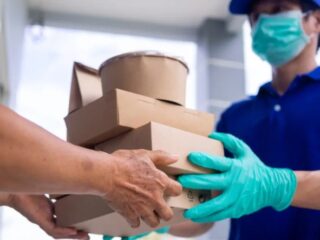 a meal delivery executive handing over a healthy meal pack