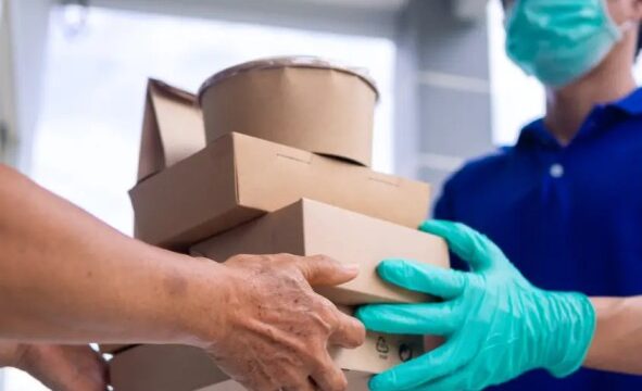 a meal delivery executive handing over a healthy meal pack