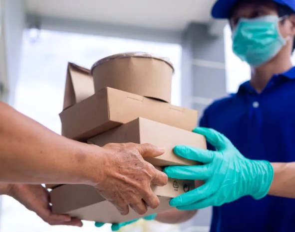 a meal delivery executive handing over a healthy meal pack